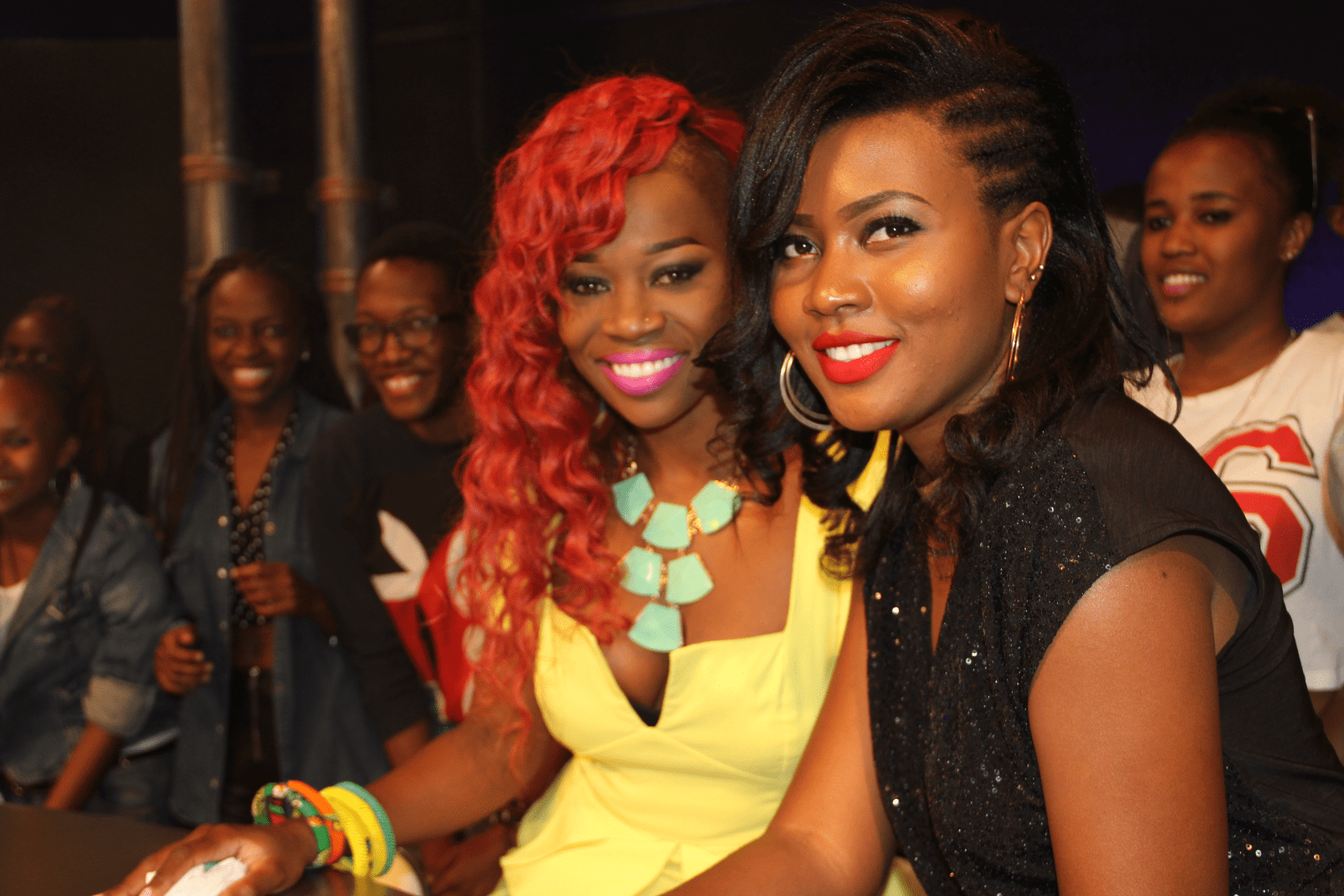 Two women with bright makeup smiling at an event